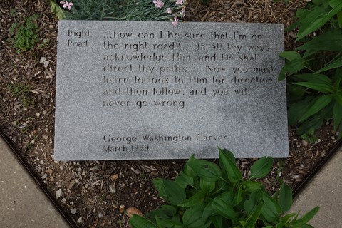 A stone granite GW Carver quote outdoor panel.