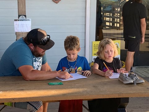 A parent helping with a Junior Ranger book.