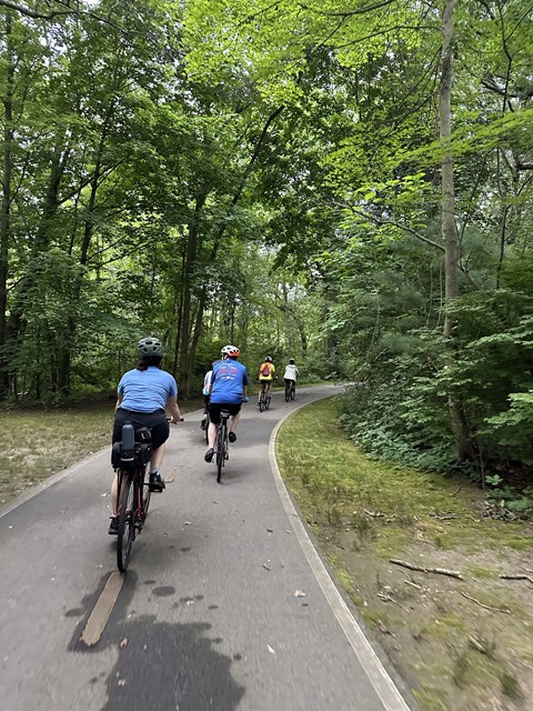People on bikes riding down paved pathway