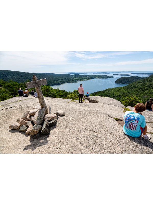 Visitors overlook islands from a mountain summit