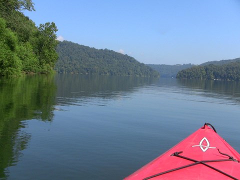 view of lake with trees on all sides from cockpit of a kayak