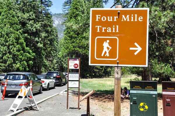 Trailhead sign with bus stop information in background