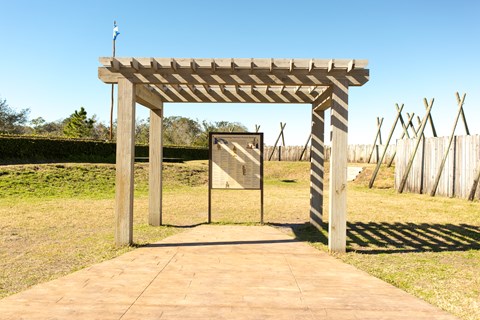 a pergola inside a fort with an exhibit panel listing names