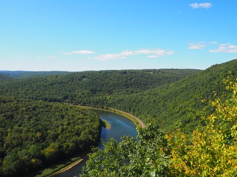 View of lush river valley with azure blue river snaking through trees