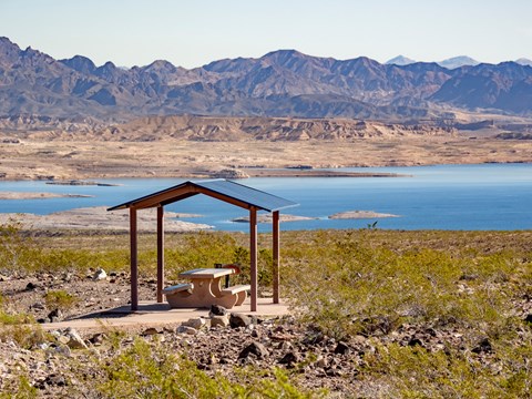 a picnic shelter with a lake in the background