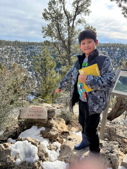 A child stands on a trail above Walnut Canyon.