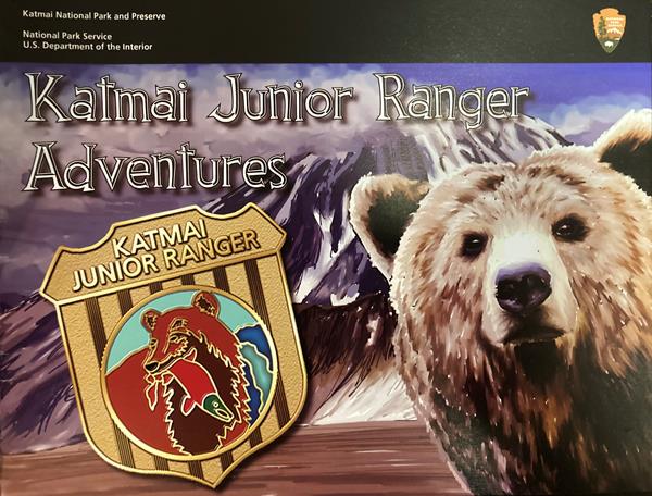 Front cover of the Jr. Ranger Book featuring Jr. Ranger badge, artistic rendering of a bear and moun