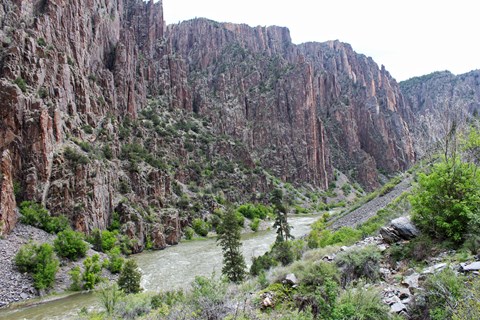A view of a steep canyon and greyish river