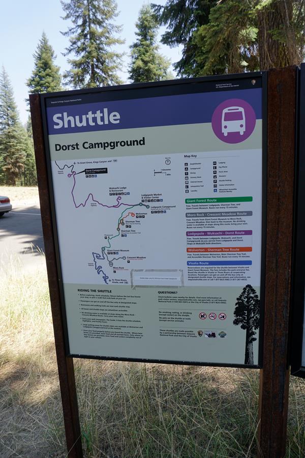 A metal panel sits in a metal frame. There is images and text with information about shuttle stops