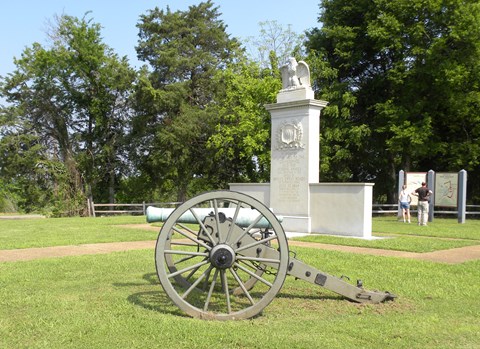 Brices Cross Roads National Battlefield Monument in middle with cannon in front.