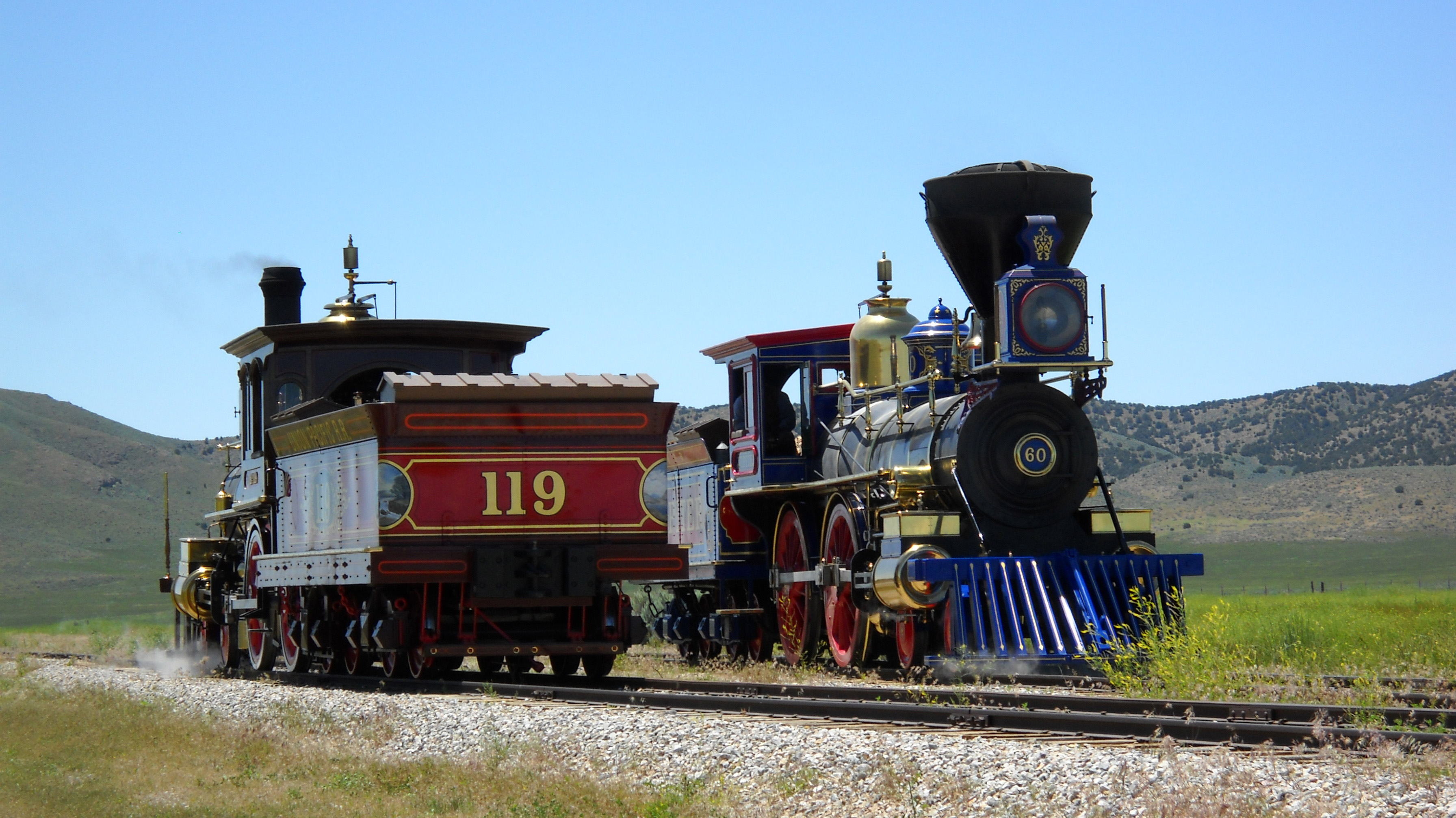 Two old locomotives, passing each other on opposite tracks.