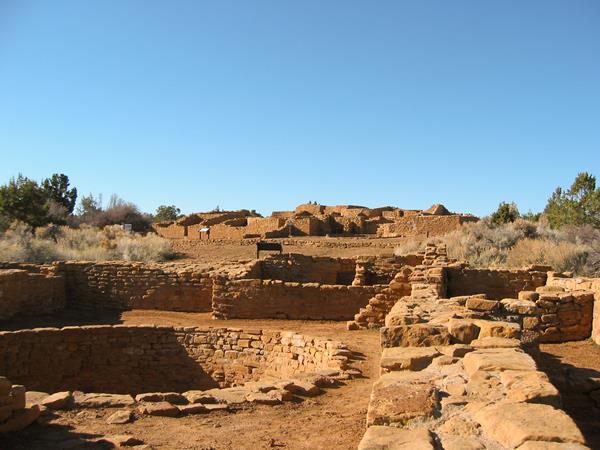 Looking across the tops of several low, ancient stone-masonry walls, both square and round.