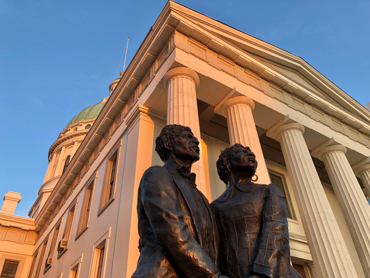 looking up at the statue of Dred & Harriet Scott with the Old Courthouse's classical columns behind