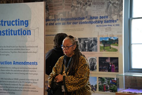 Two people look at colorful exhibit displays that surround them.
