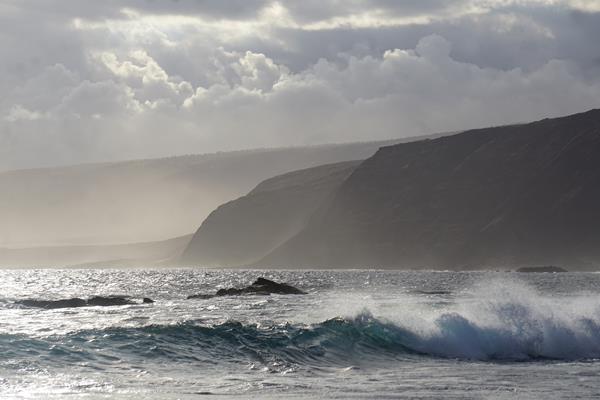 Ocean waves and coastal cliffs shortly before sunset