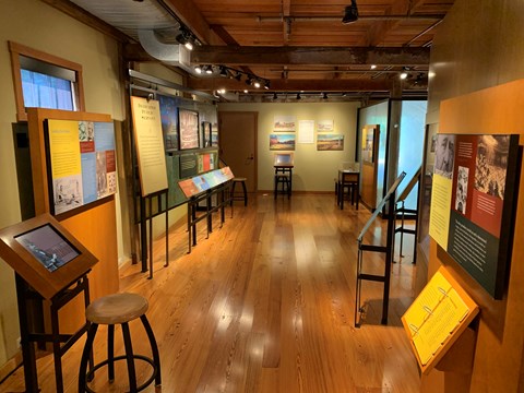 Museum with computer to the left and textual exhibits on all sides.