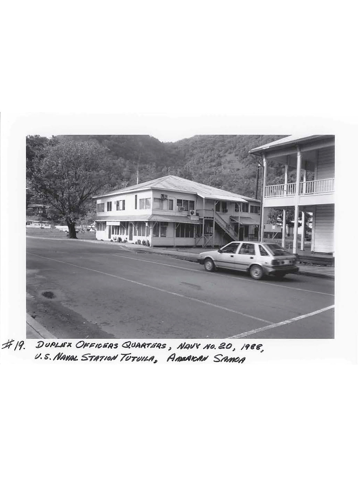 Black and white photo, 2 story building set off the main road