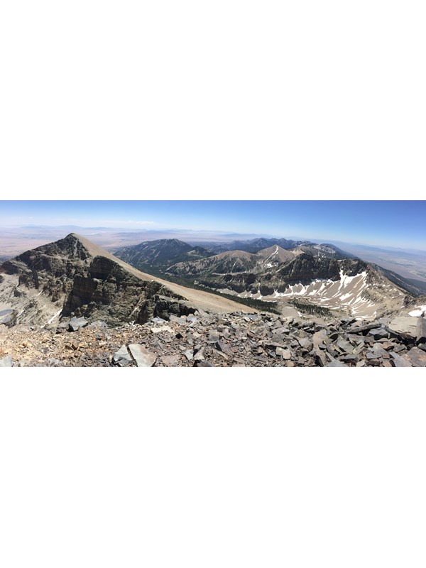 View from wheeler peak with blue skies and rocky mountain peaks.