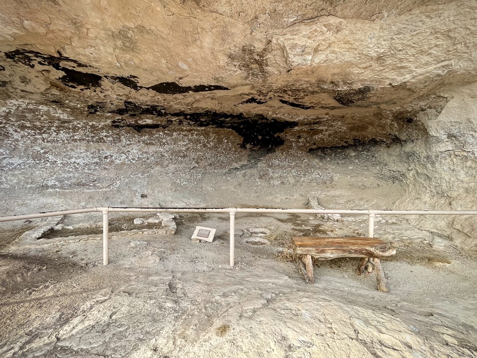 Dirt floor with outlines of buildings in a alcove.
