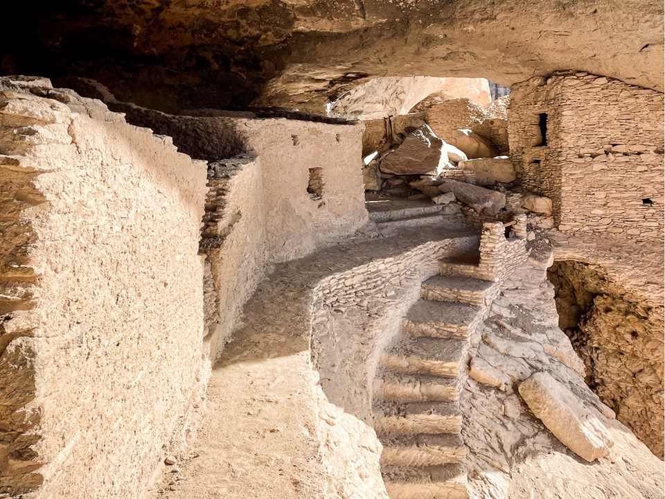 Narrow stone walkway with a two-story building in the background.