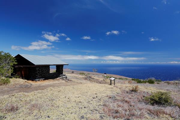 A stone shelter on a hillside overlooking the ocean