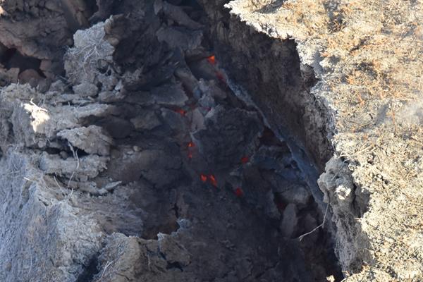 Glowing coals are visible through clay.