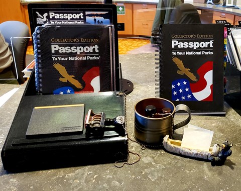 Desktop display with National Parks passport books and date stamp.