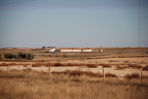 View of a ranch-style building inside a fenced compound