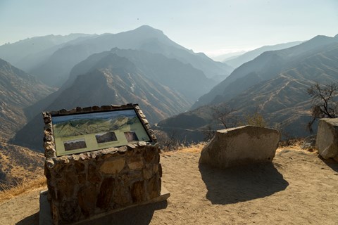 Metal interpretive sign labeling the mountain peaks visible in the canyon
