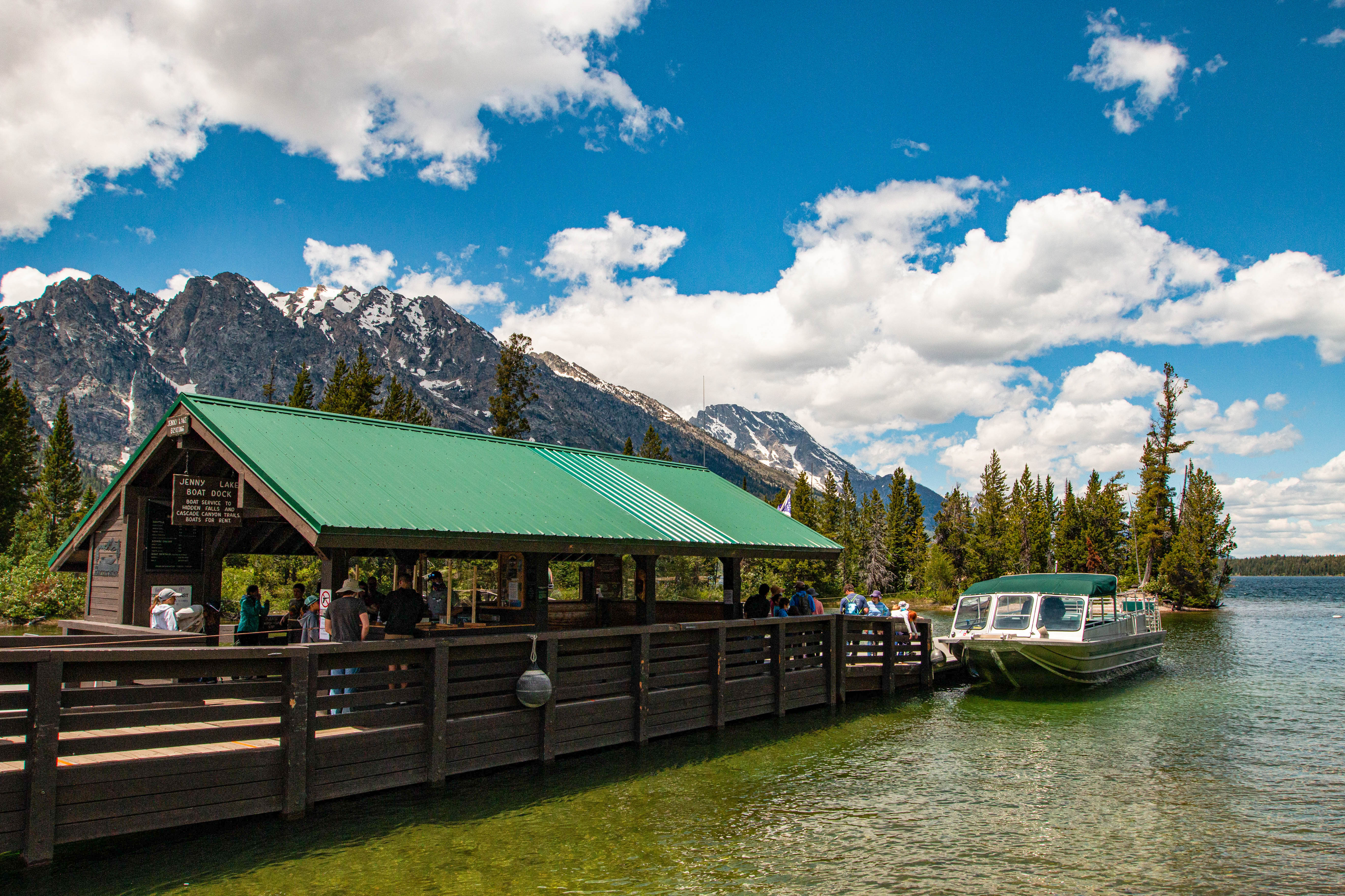 Jenny Lake East Shore Boat Dock, boat, and passengers buying tickets. Mountains in the background.