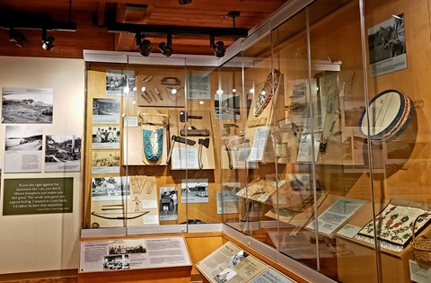 Interior view of a museum display of artifacts in a glass case.