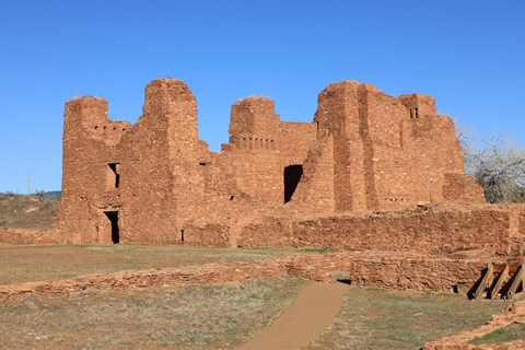 Red sandstone church remnants against a blue sky background.