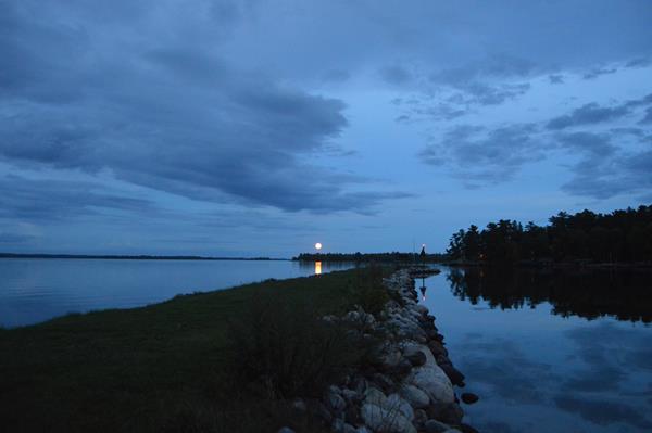 The moon rises over Lake Kabetogama with a jetty in the foreground