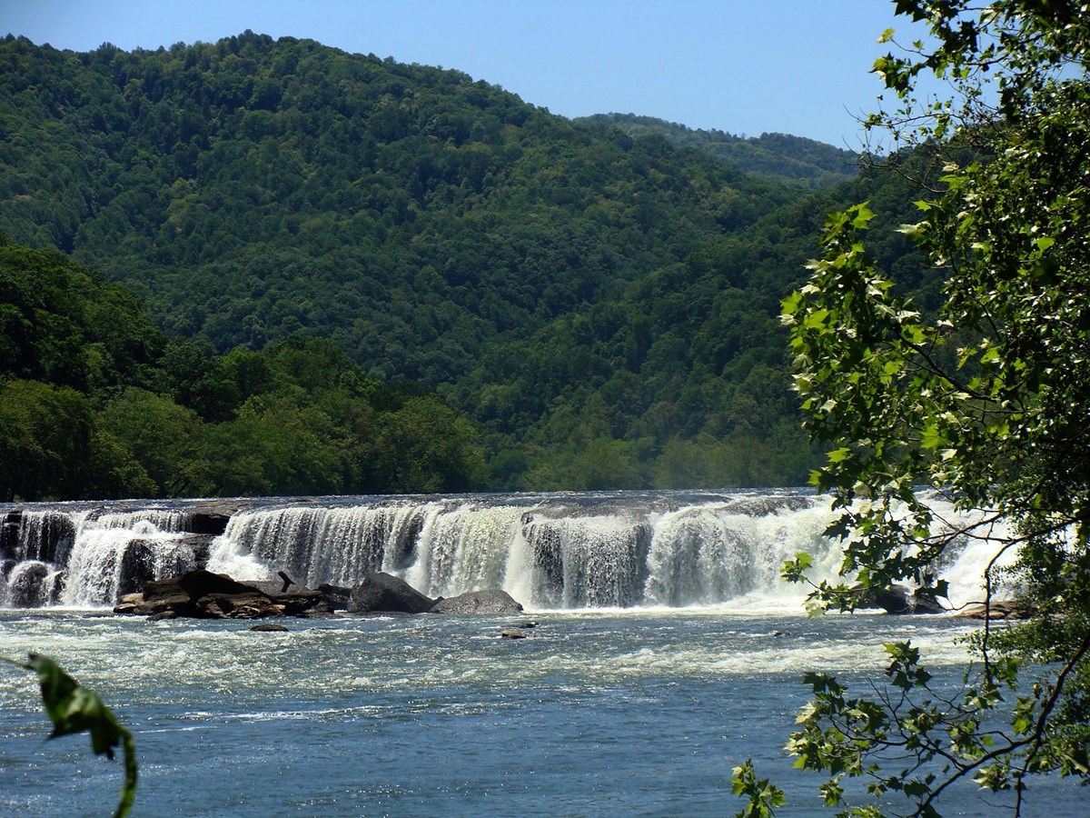 A large waterfall spanning across a wide river