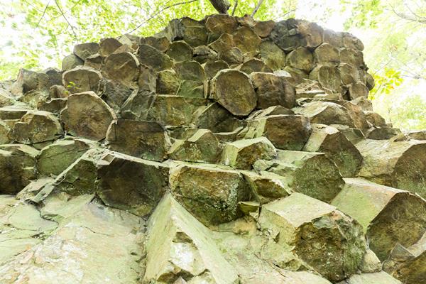 A cliff of rocks, shaped like pentagons, stands above