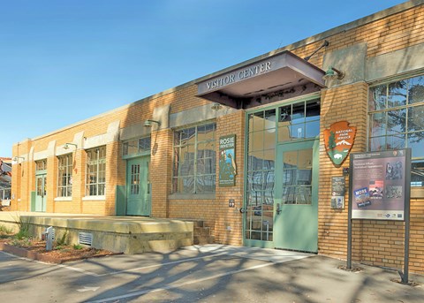 Front of Visitor Education Center building. Brick building with multiple glass windows.