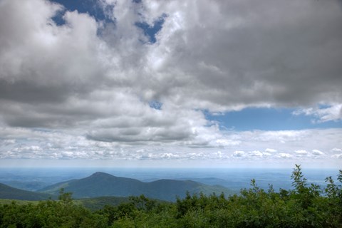 A view from on top of the summit of a mountain.