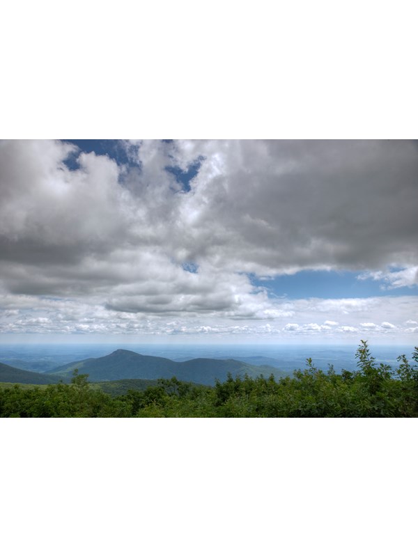 A view from on top of the summit of a mountain.