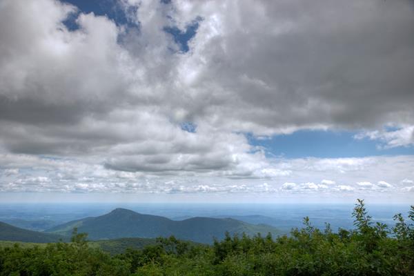 A view from on top of the summit of a mountain.
