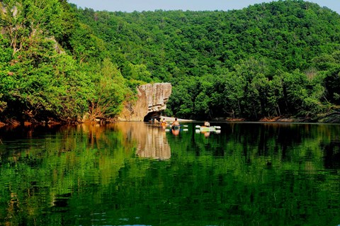 Several kayakers paddle towards Skull Rock.