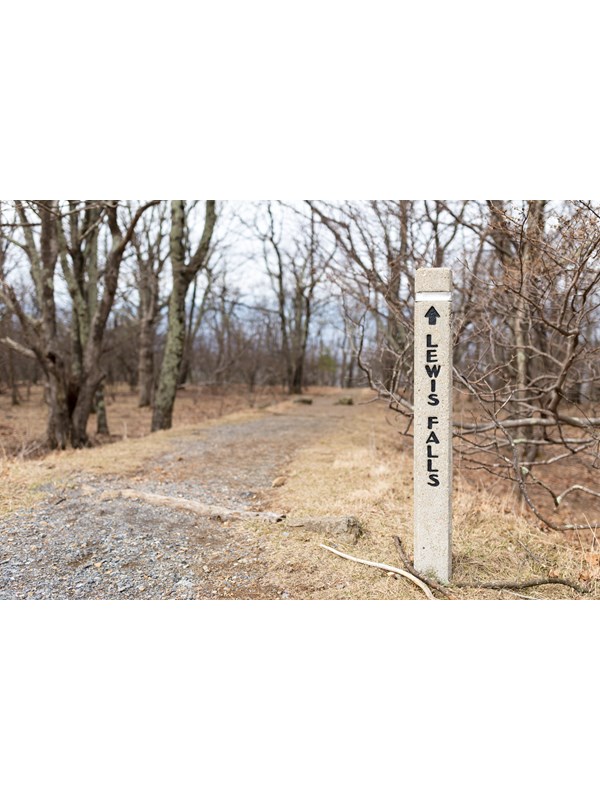A concrete post at the head of a trail the reads Lewis Falls