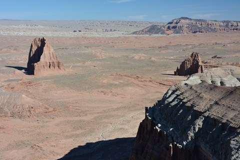 View looking down on triangular, reddish orange monoliths in a desert.