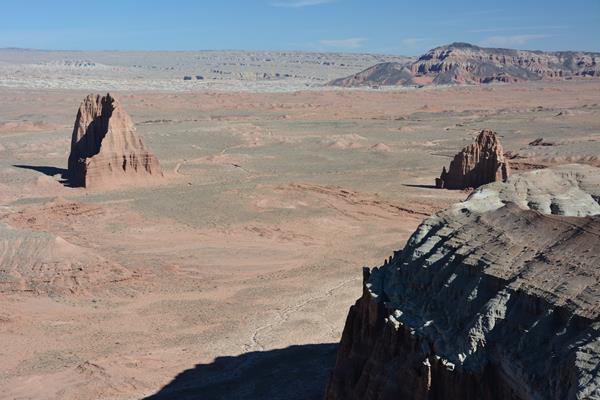 View looking down on triangular, reddish orange monoliths in a desert.