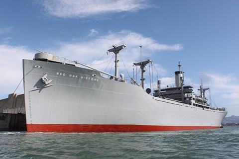Large WWII ship sitting at dock.