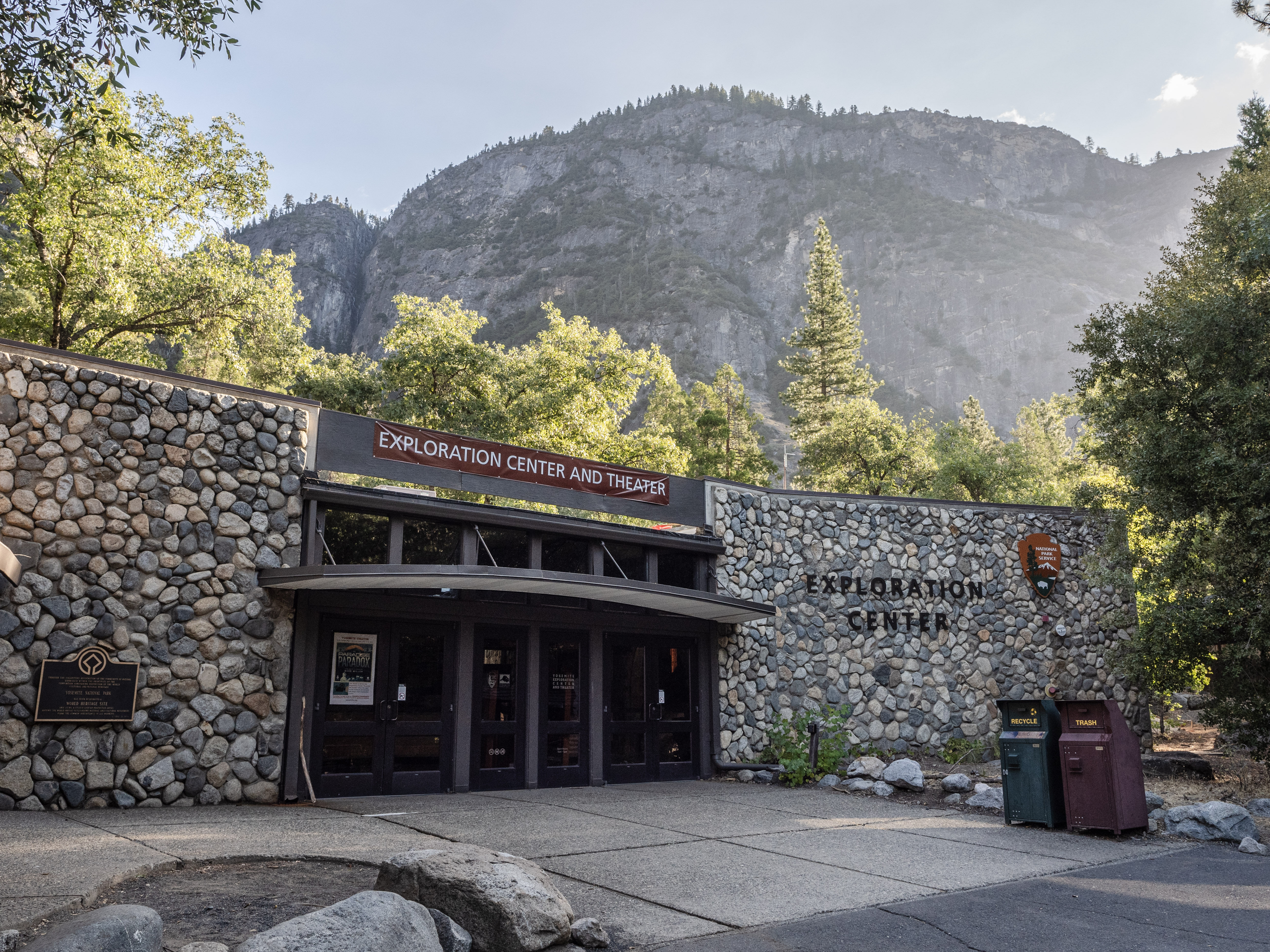 A single story building with glass doors framed by large rock walls on both sides
