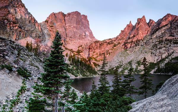 the sun shines on a mountain ridge and lake