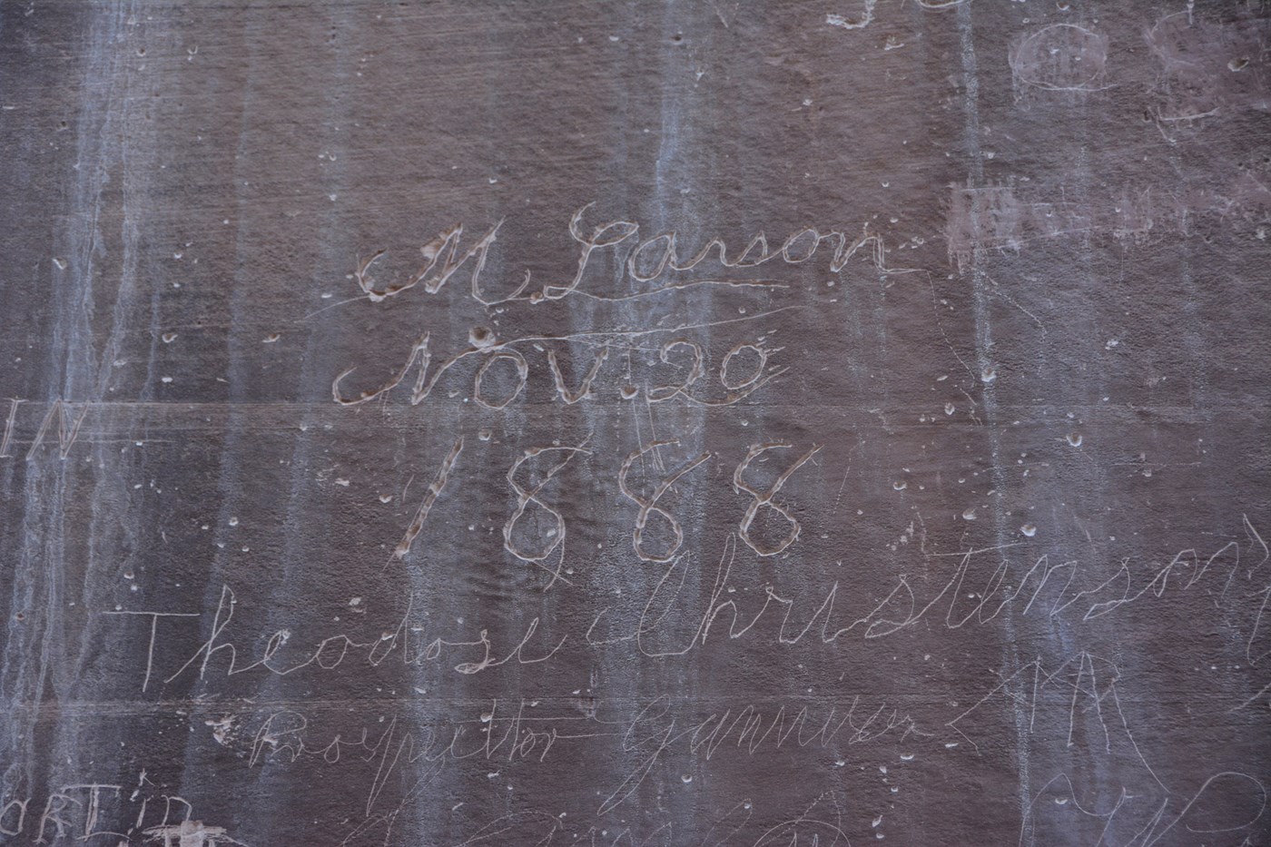 Signatures carved into the reddish canyon wall at the Pioneer Register