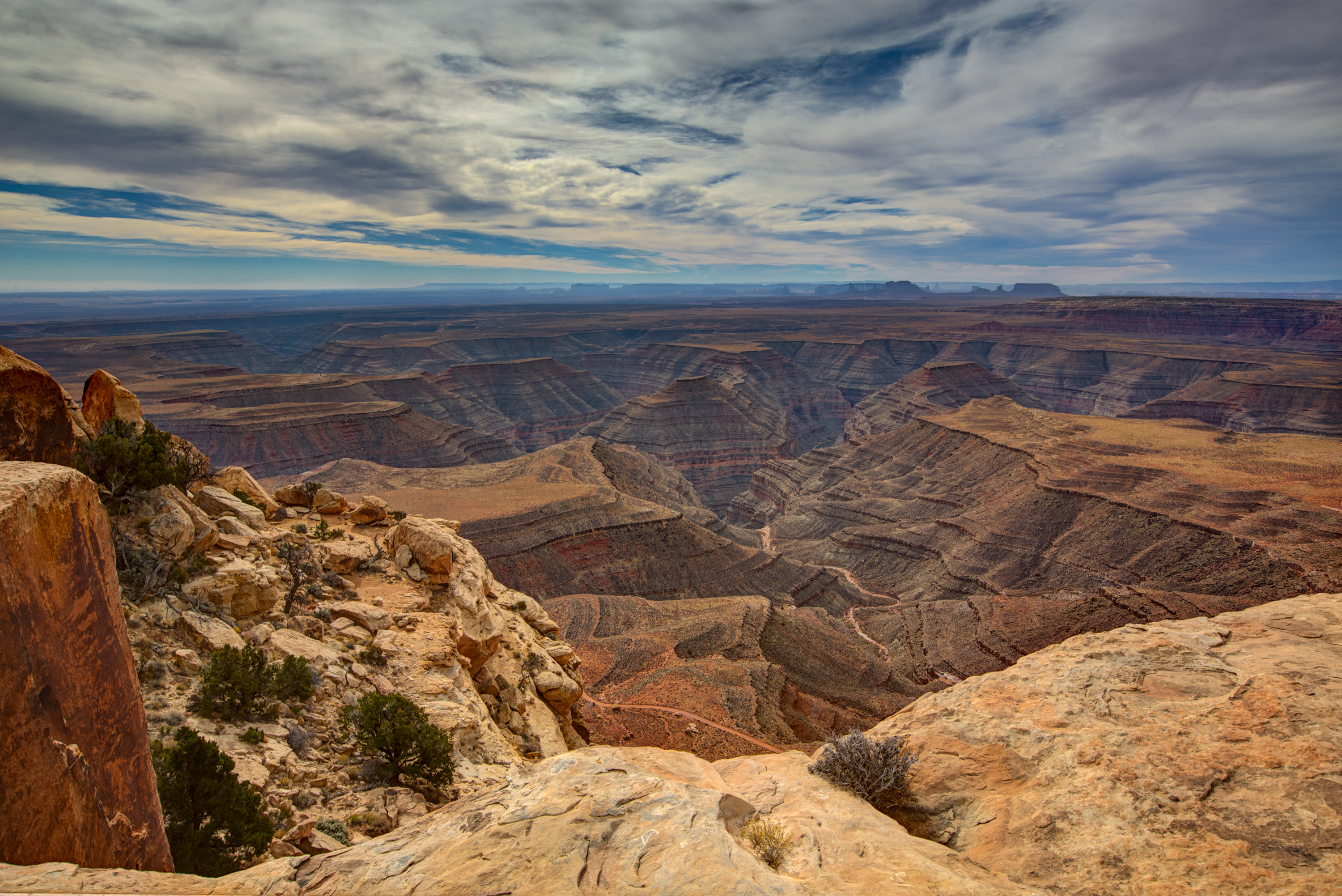 Sandstone canyons overlooking stepped canyon, with butte in the distance