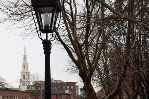An historic lamp post, steeple, and trees