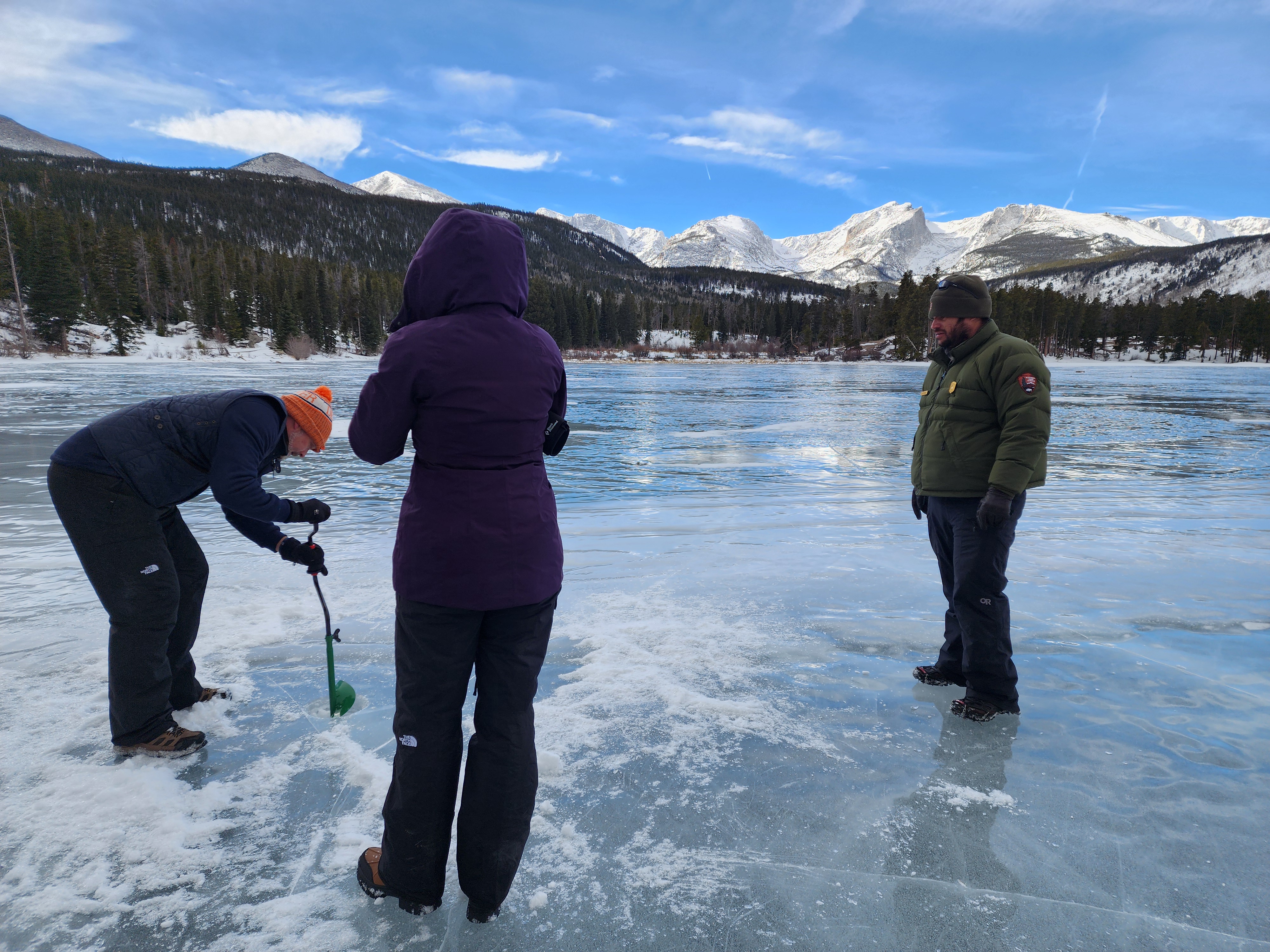 Two park visitors are trying ice fishing